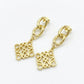 Macro detail of the Loewe Anagram pendant earrings showing the precision polished edges