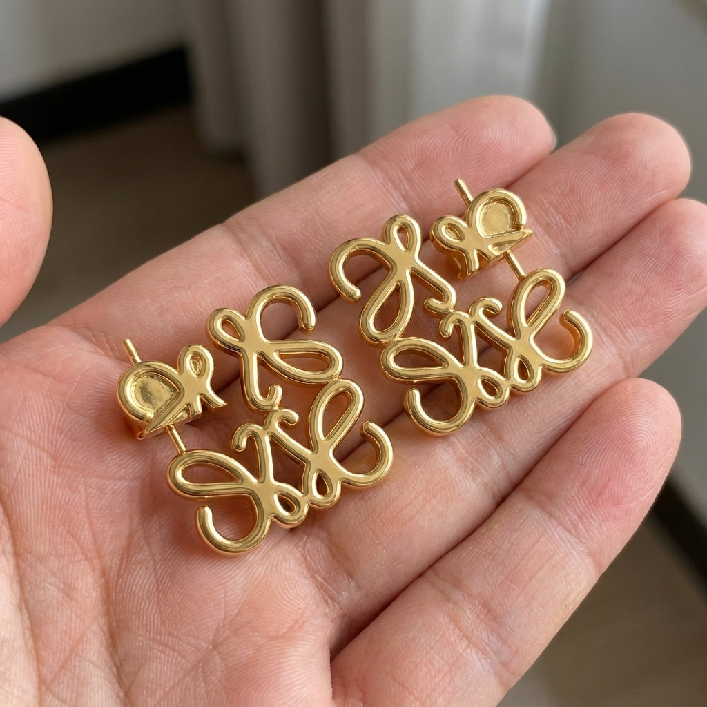Hand-held size reference of the Loewe Anagram Hollow Studs to show the delicate scale