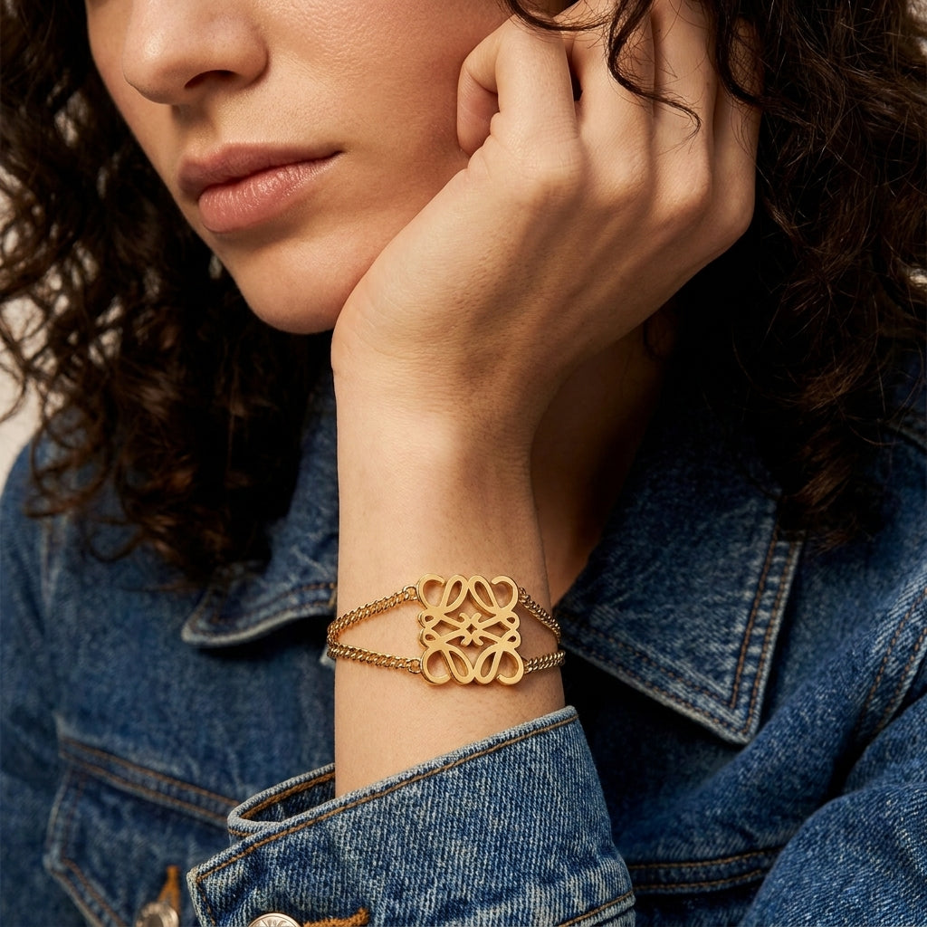 Model touches hair wearing Loewe Silver Metal Bracelet, capturing the metallic gleam