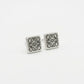 Macro detail of the silver square Anagram studs showing the precision polished edges