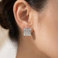 Model touches hair wearing Loewe Pavé Studs, capturing the brilliant sparkle in motion