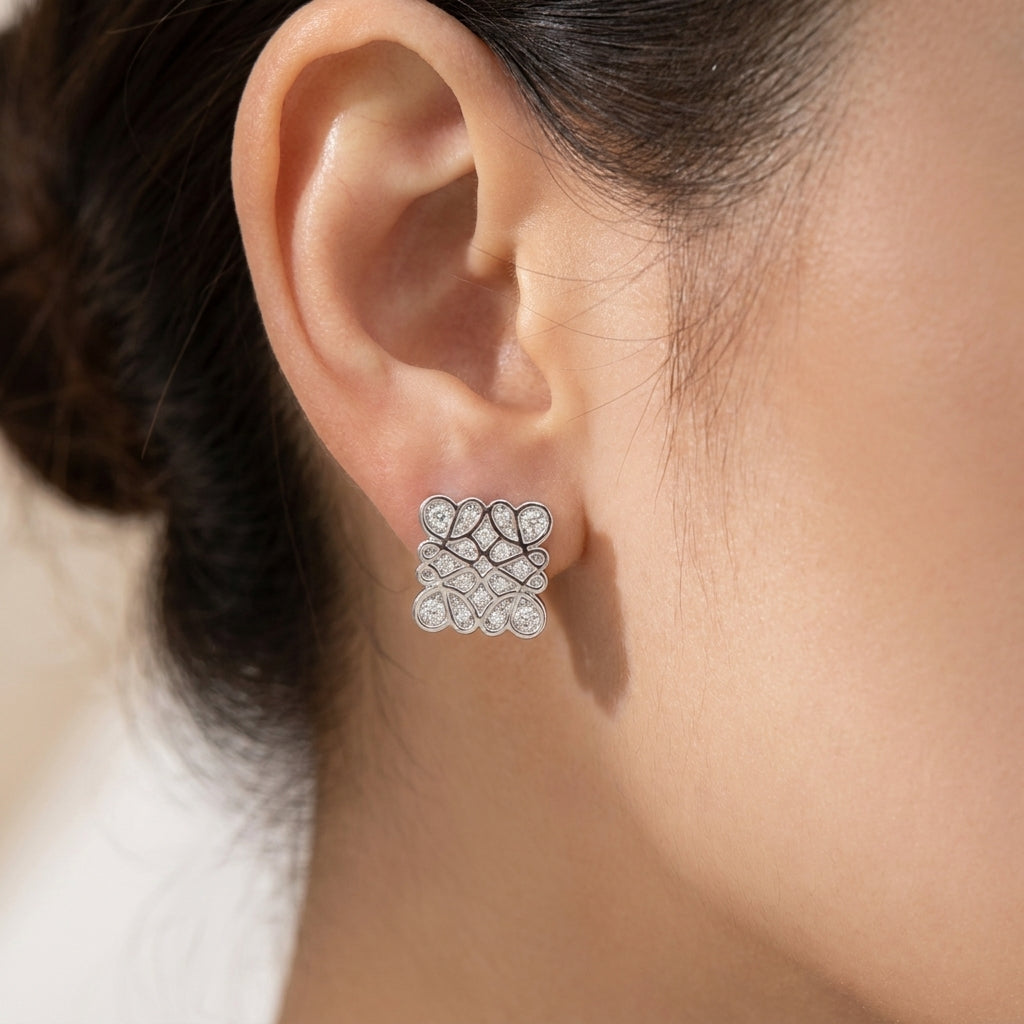 Model touches hair wearing Loewe Pavé Studs, capturing the brilliant sparkle in motion