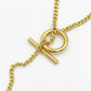 Macro detail of the silver toggle clasp and Anagram pendant showing the high-polish finish