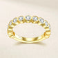Symmetrical frontal studio view of a luxury bezel setting brilliant cut cz alternative ring resting on a textured cream surface.
