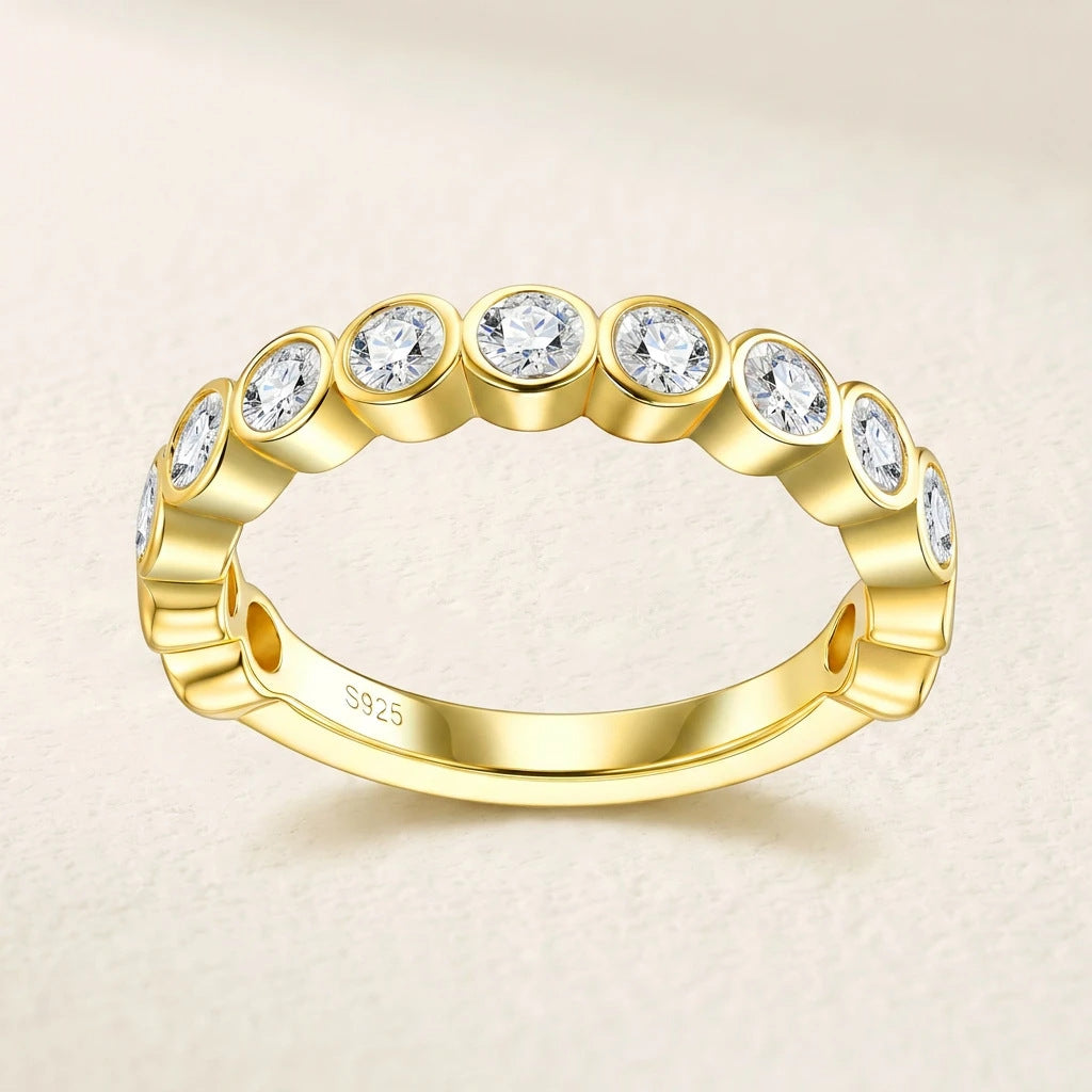 Symmetrical frontal studio view of a luxury bezel setting brilliant cut cz alternative ring resting on a textured cream surface.