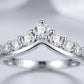 Close macro studio portrait of a luxury contour v shape moissanite guard ring showcasing the shared prong claw detail.
