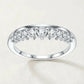 Symmetrical frontal studio portrait of a luxury contour v shape moissanite guard ring highlighting the curved tiara arch.