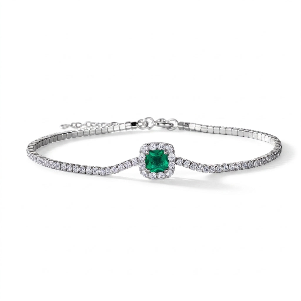 Flat lay studio product shot of a luxury cushion-cut lab-grown emerald tennis bracelet with a micro-pave halo.
