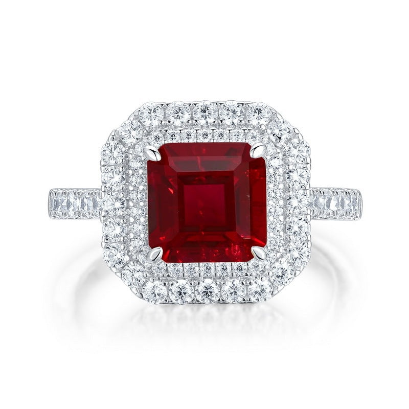 White background front view showcasing a luxury emerald-cut ruby double halo statement ring with a pave diamond band.