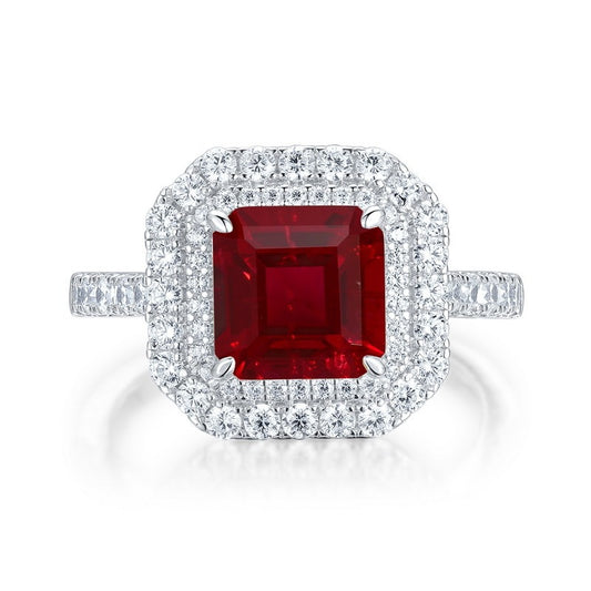 White background front view showcasing a luxury emerald-cut ruby double halo statement ring with a pave diamond band.