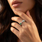 Close-up lifestyle view of a moody model showcasing a luxury emerald serpent totem open ring resting against her chin.