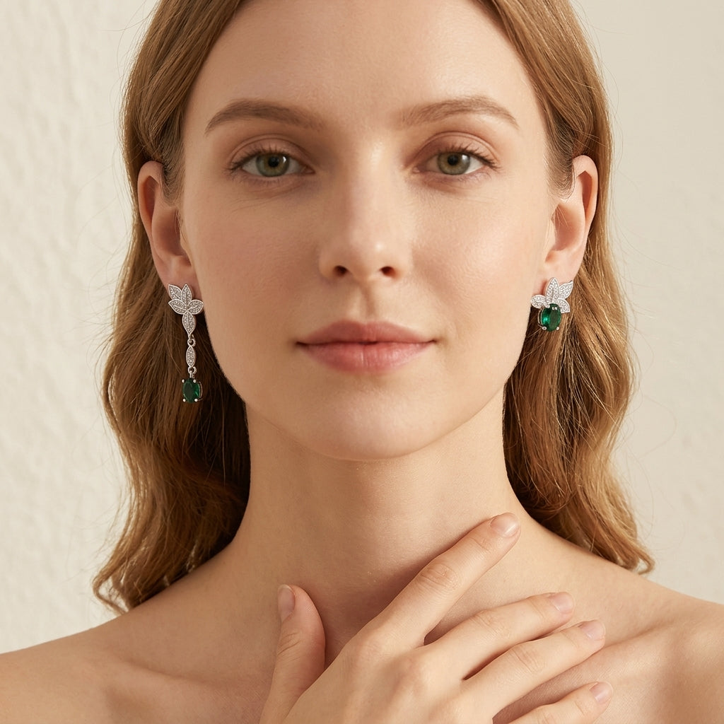 Woman wearing emerald green earrings with a neutral background