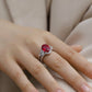 Side angle lifestyle shot of a model showcasing a luxury oval ruby split-shank ring on her finger.