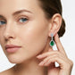 Close-up lifestyle view of a model showcasing the luxury pear-cut emerald openwork halo drop earrings.