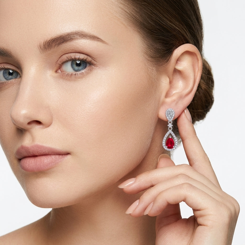 Close-up lifestyle view of a model showcasing the luxury pear-cut ruby openwork halo drop earrings.