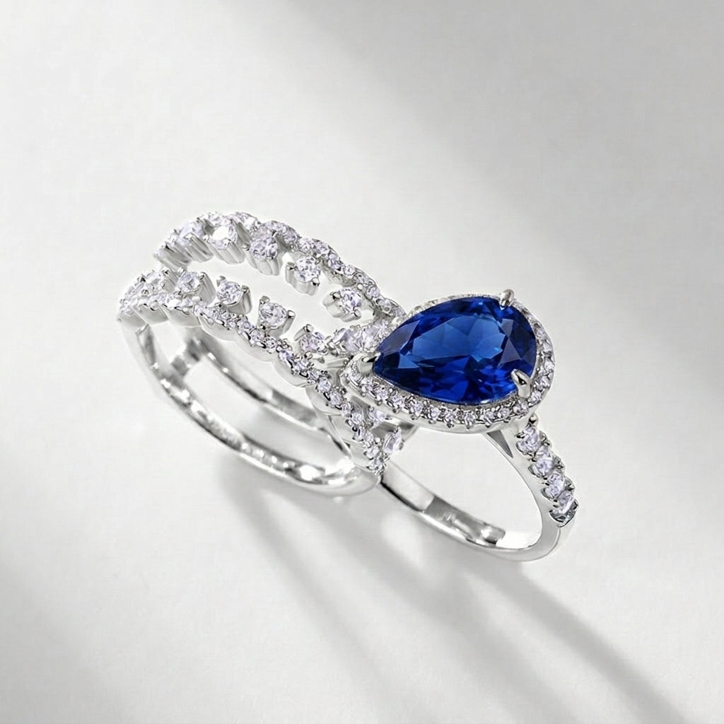 Side view of a premium luxury pear-cut blue sapphire 2-piece stacking ring combo showcasing precise prong artistry.