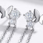 Micro profile view showing the sterling silver butterfly wing, brilliant round moissanite setting, and delicate tassel chains.