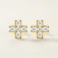 Studio pair display of luxury pear shaped gemstone floral stud earrings highlighting gold bezel setting detail.
