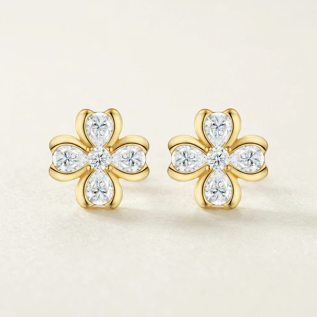 Studio pair display of luxury pear shaped gemstone floral stud earrings highlighting gold bezel setting detail.