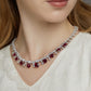 Close-up of a model wearing a luxury cushion-cut ruby fringe statement necklace on the neckline.