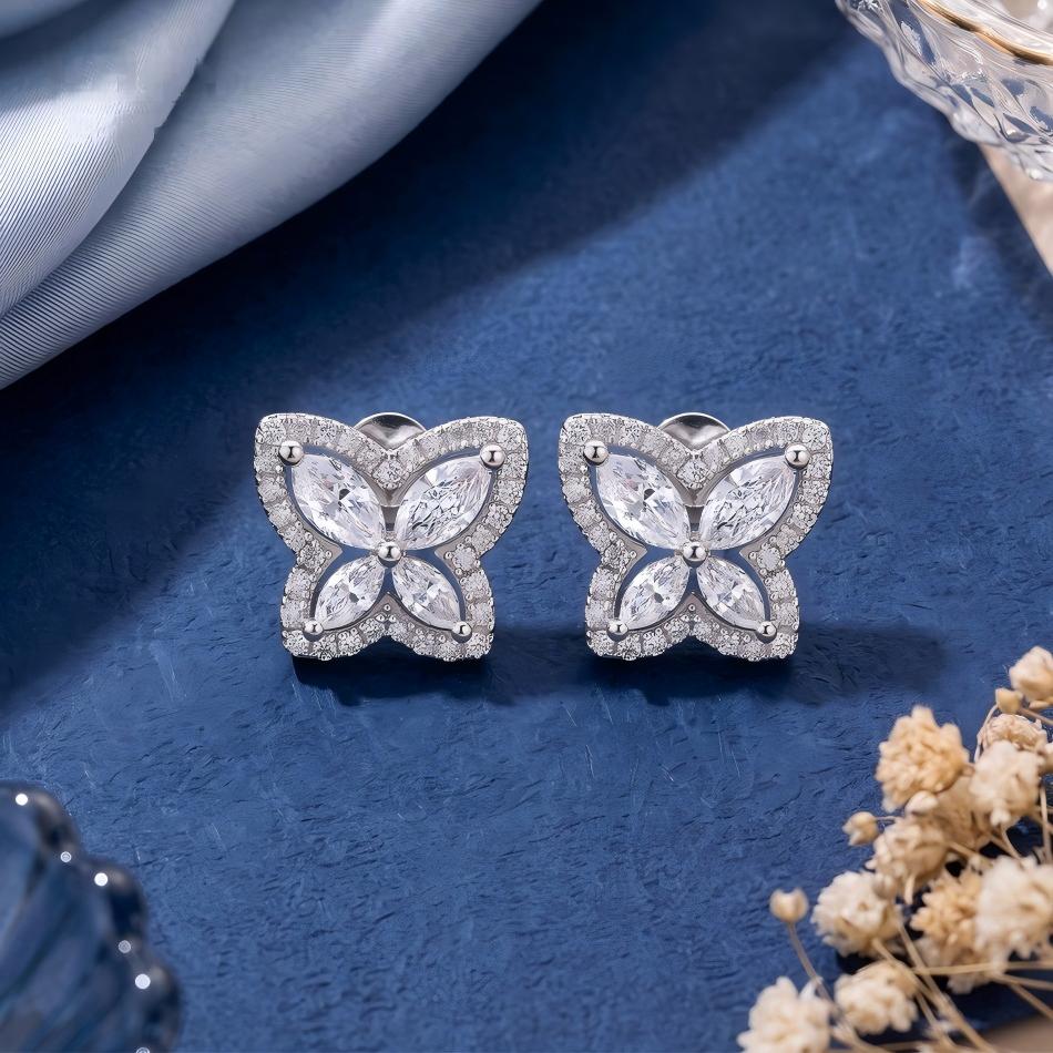 Pair of marquise butterfly halo stud earrings displayed on blue silk.