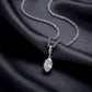 Perspective view of marquise cut lab diamond bezel pendant necklace resting on black silk fabric.