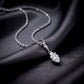 Marquise cut lab diamond solitaire bezel drop pendant with filigree bail on dark silk background.
