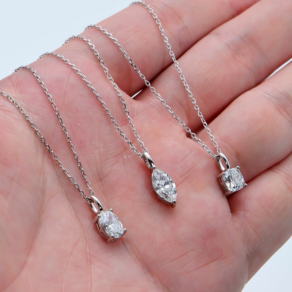 Hand holding three fancy cut lab diamond solitaire pendant necklaces.