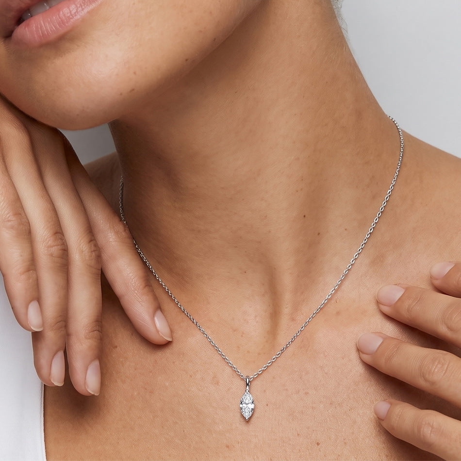 Model wearing marquise cut lab diamond solitaire necklace on collarbone.