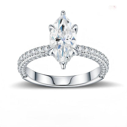 Marquise cut moissanite solitaire engagement ring with multi-row pave band on white background.