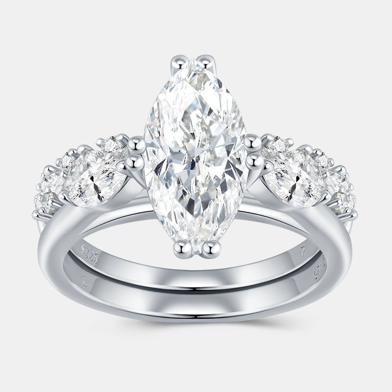 Marquise cut moissanite three stone engagement ring with matching curved band on white background.