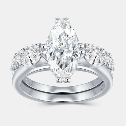 Marquise cut moissanite three stone engagement ring with matching curved band on white background.