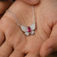 Real-life lifestyle hand view of a model holding a luxury marquise-cut ruby butterfly pendant necklace in her palm.