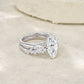 Angled view of marquise cut moissanite three stone engagement ring and matching band.