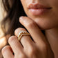 Model wearing gold marquise cut moissanite crown tiara stacking ring in a daylight shot.