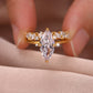 Close-up view of gold marquise cut solitaire ring with matching crown band held in hand.