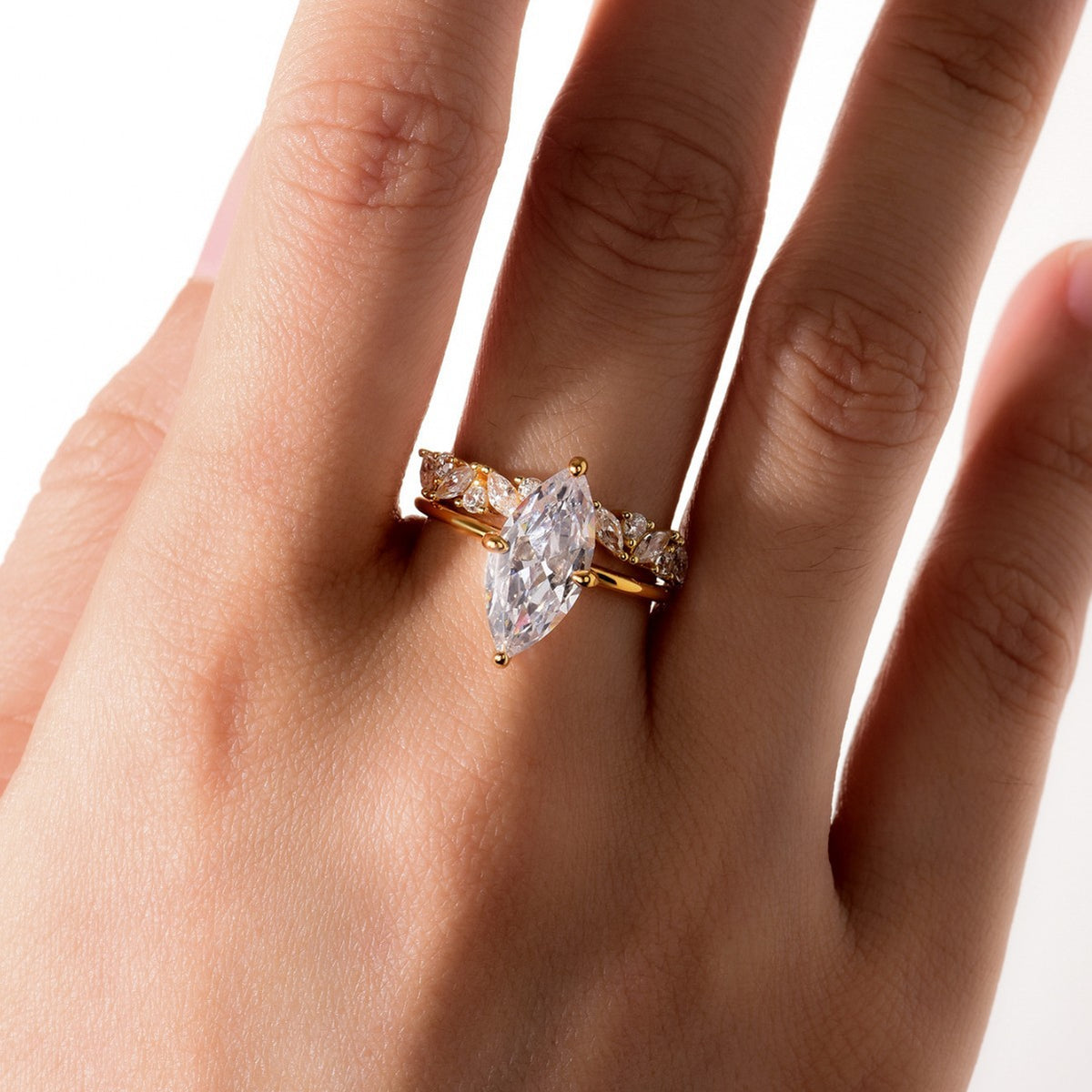 Model wearing marquise cut moissanite solitaire nested with crown stacking band.