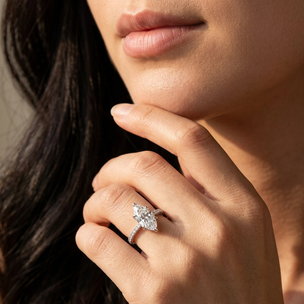 Close-up view of a model wearing marquise cut moissanite engagement ring with multi-row pave band.