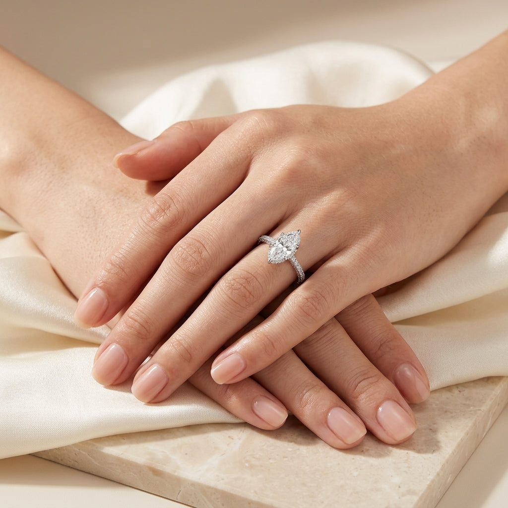 Model wearing marquise cut moissanite engagement ring with multi-row pave band in soft ambient lighting.