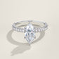 Silver marquise cut moissanite solitaire ring with pave shank standing on soft cream background.
