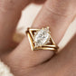Top-down hand shot of model wearing gold marquise cut moissanite solitaire and wishbone chevron ring set.