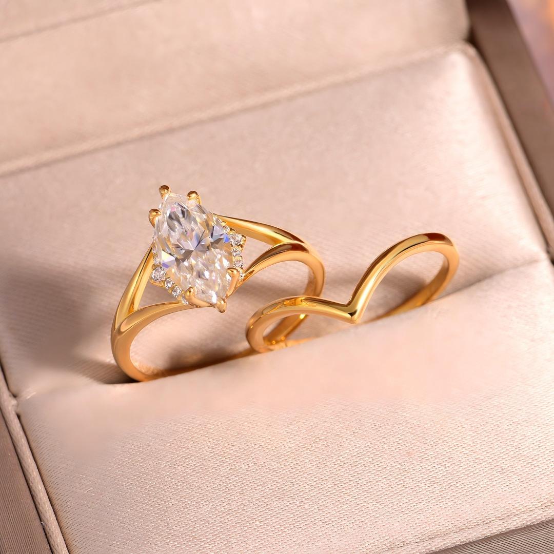 Angled shot of gold marquise solitaire and wishbone chevron stacking ring set in jewelry box.