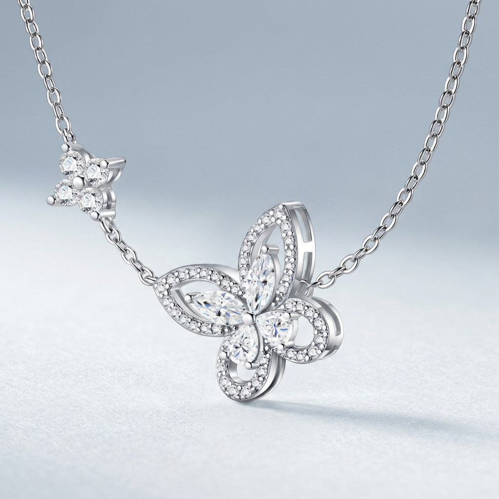 Perspective view of marquise and pavé moissanite butterfly floral necklace on slate background.