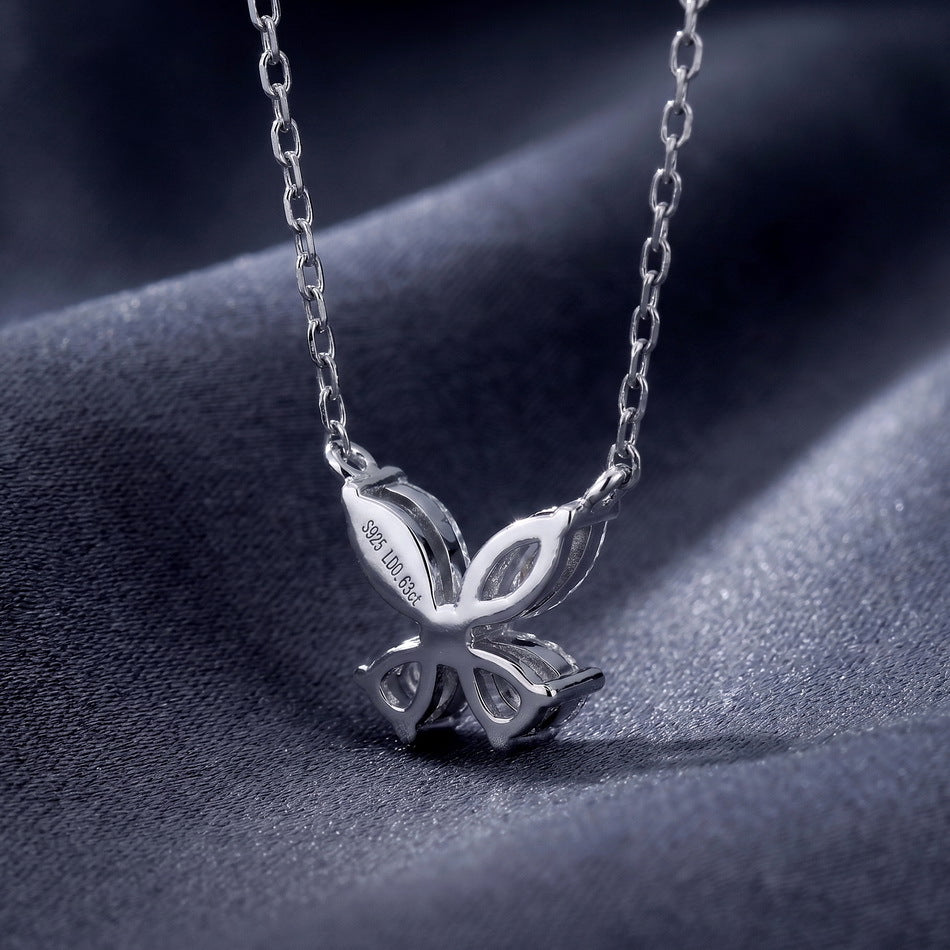 Close-up rear basket view of marquise and pear cut lab diamond butterfly pendant on dark silk.