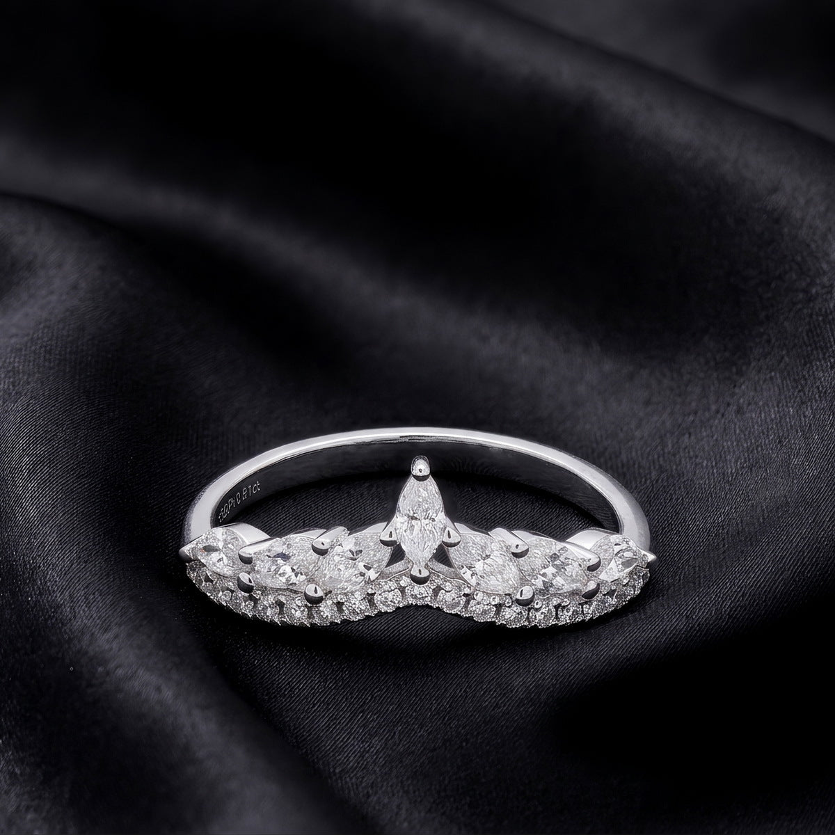 Front view of marquise and round lab grown diamond curved wishbone ring on dark black silk