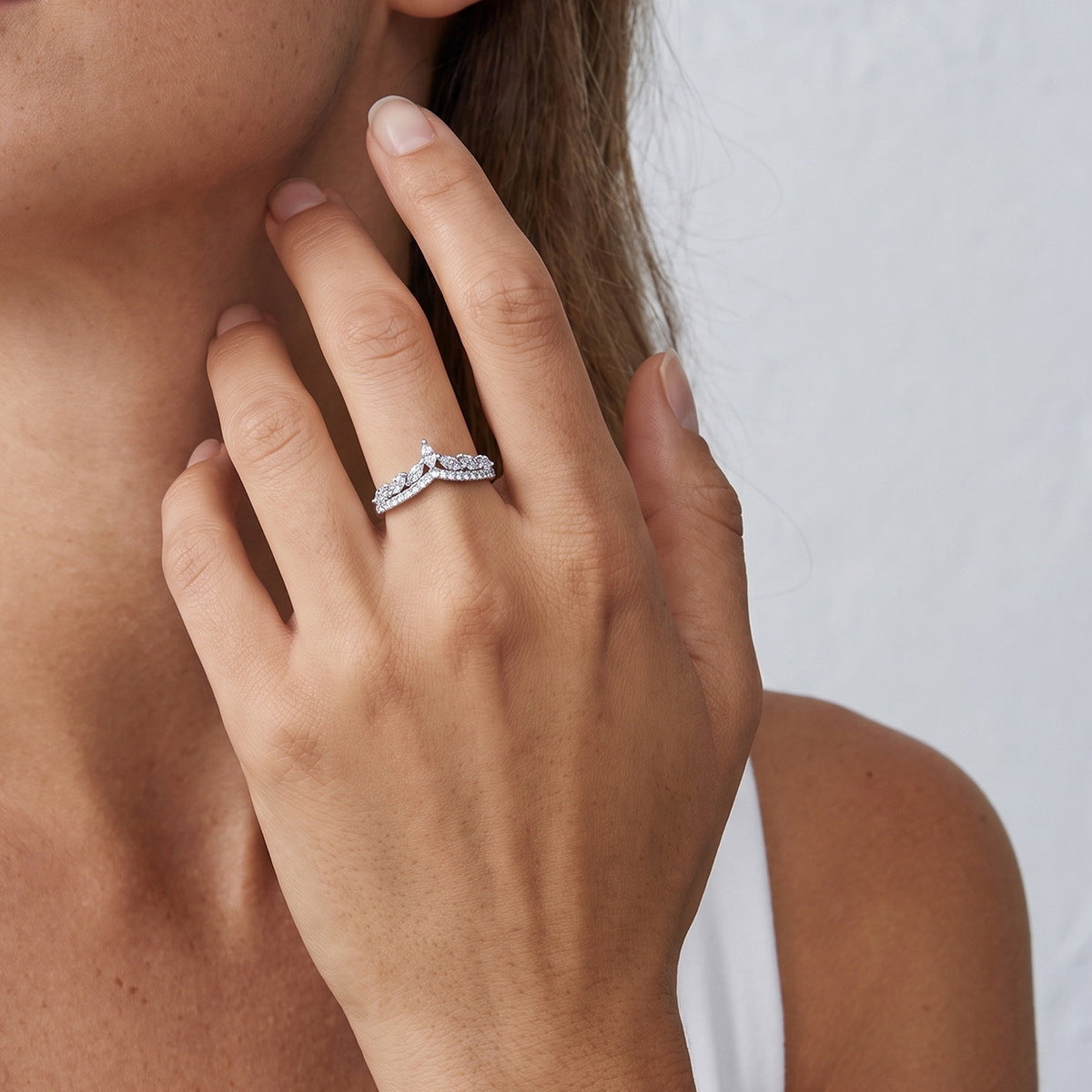 Woman wearing marquise and round lab grown diamond curved wishbone stacking ring on finger