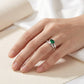 Side angle lifestyle shot of a model showcasing a minimalist marquise-cut emerald bypass engagement ring on her finger.