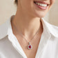 Editorial portrait view of a smiling model wearing a minimalist ruby cushion frame pendant necklace with a crisp white shirt.