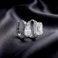 Perspective shot of asymmetric pear and emerald cut lab diamond bezel huggie hoop earrings.