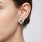 American woman wearing ruby flower stud earrings with a casual chic outfit.